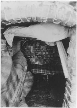 Le 19 avril 1943 / 19 avril 2009 Les Juifs ont résisté ! Chant des résistants juifs du ghetto de Vilnius Photo prise depuis l'entrée étroite d'une cave. Au fond, une couchette recouverte d'une couverture à carreaux.