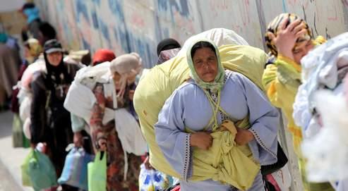 Des Marocaines, transportant des fardeaux qui pèsent jusqu'à 70 kilos, font la queue au poste de frontière de Biutz.