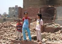 Des enfants se tiennent sur les décombres de leurs maisons dans le quartier d’Establ Antar (Égypte, 5 août 2009).