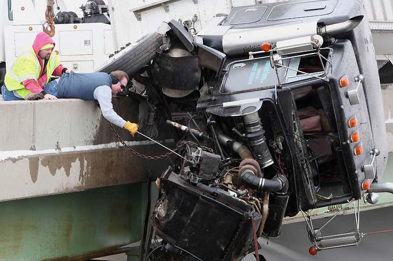 Des remorqueurs tentent de soulever la carcasse de ce camion coincé sur la barrière d’un pont à Muncie, ville de l’Indiana aux États-Unis, mercredi 17 février. Fort heureusement, le conducteur est sorti indemne de cet accident. 