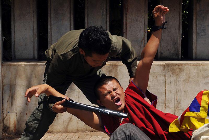 Un jeune étudiant tibétain est frappé au sol par un policier lors d’une manifestation, à Bangalore, mercredi 10 mars. Ce jour marque le 51ème anniversaire du soulèvement tibétain contre le gouvernement chinois. 