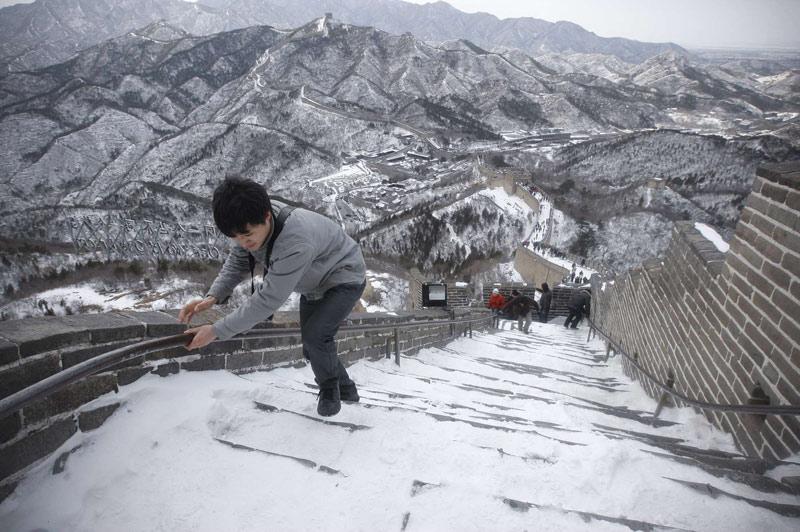 Ce touriste peine à monter les marches enneigées de la Grande Muraille de Chine, lundi 15 mars. Depuis 1987, la Grande Muraille est classée au patrimoine mondial de l'UNESCO.
