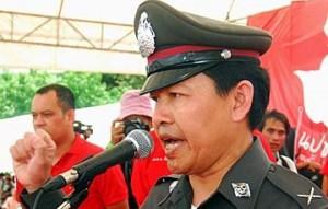 Un policier en uniforme s’exprime à la manifestation des chemises rouges