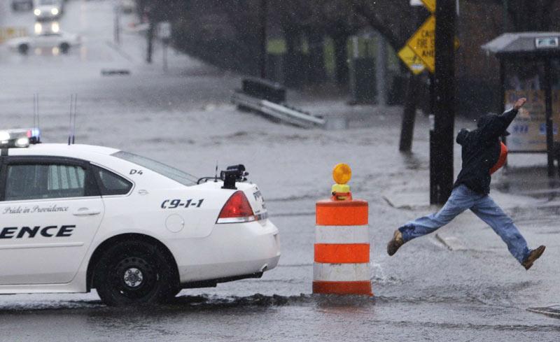À Providence, dans l’État de Rhode Island, aux États-Unis, une rue inondée oblige un habitant à faire preuve d’un bon élan pour sauter au dessus de grandes flaques, mardi 30 mars.