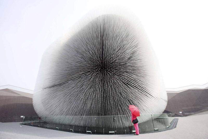 Jeudi 6 mai à Shanghai, cette femme admire l’originalité du pavillon anglais appelé aussi ''Cathédrale de graines''. Ce gros oursin, de forme cubique est hérissé de 60.000 tiges d'acrylique qui contiennent autant de graines provenant des recherches exploratrices sur la diversité végétale.