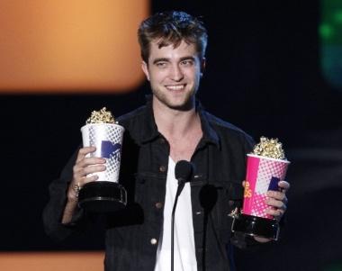 Actor Robert Pattinson accepts awards for Best Male Performance and for Global Superstar at the 2010 MTV Movie Awards in Los Angeles, June 6, 2010. REUTERS/Mario Anzuoni (UNITED STATES - Tags: ENTERTAINMENT IMAGES OF THE DAY)