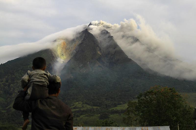 Fuite. Lundi 30 août, un homme et son fils observent le volcan du mont Sinabung, sur l'île indonésienne de Sumatra, entré en éruption la veille après 400 ans de silence. 3000 réfugiés ont été contraints de quitter leurs villages et ont été évacués vers seize centres de secours.