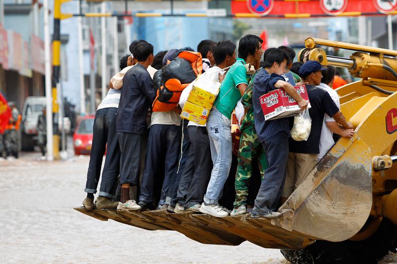 Les rues étant envahies d'eau et de boue, tous les moyens sont utilisés pour se déplacer à Zhouqu, ville de la province chinoise de Gannan. Lundi 9 août.