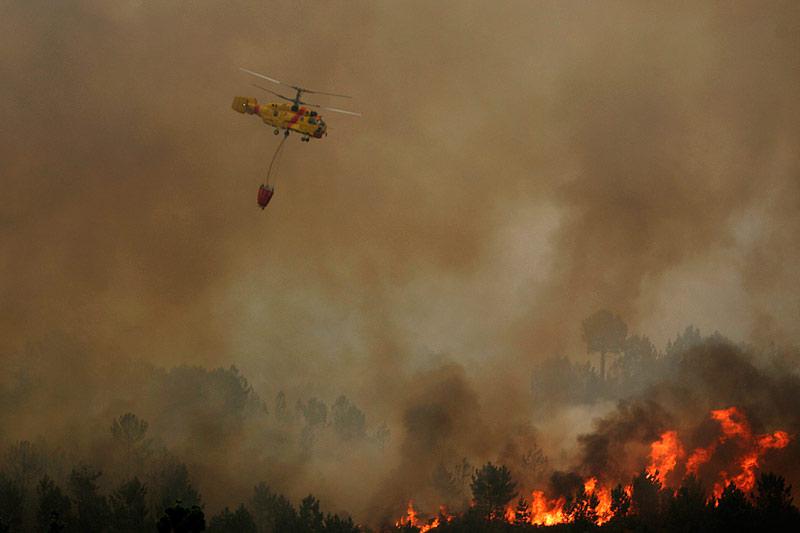 Dimanche 8 août, plus de 700 pompiers sont mobilisés pour éteindre une douzaine d'incendies qui ravagent les forêts portugaises. Un hélicoptère survole un feu à Carvalhal, près de Sao Pedro do Sul.