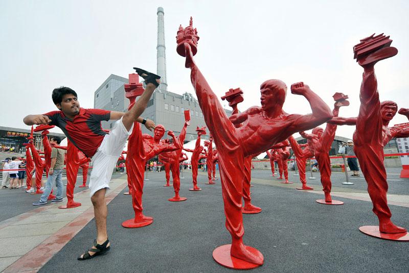 A l’exposition universelle de Shanghai, un touriste indien pose à côté des statues de Bruce Lee.