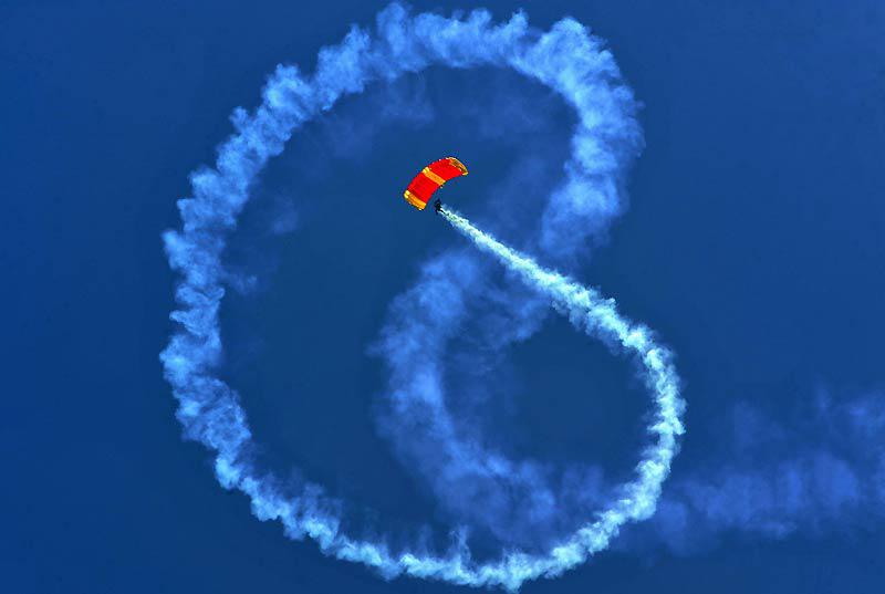 Un parachutiste de l'armée colombienne trace des figures dans le ciel avec de la fumée colorée, lors du salon Expodefensa qui s’est déroulé dimanche 18 avril, à Cali. 