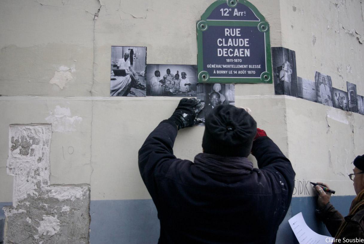 Remy encollant des photos mémoire du lieu prises par Claire Sousbie et Jérome Barbosa avant l'expulsion - Cyrille inscrivant en frise tous les prénoms des derniers occupants de la MEEAO