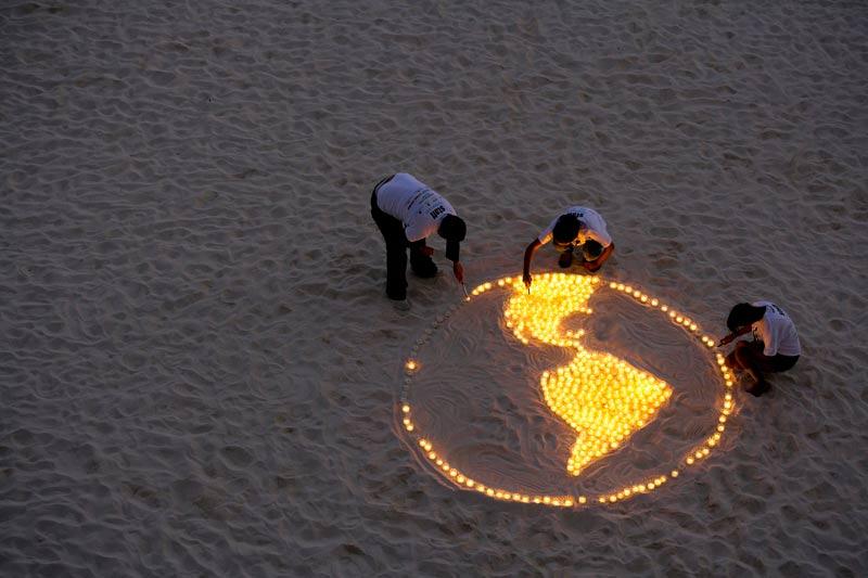 Alors que se tient en ce moment au Mexique le sommet international sur la lutte contre le réchauffement climatique, des membres du WWF ont déposé, lundi 6 décembre, sur la plage de Cancun, des bougies représentant la terre. 