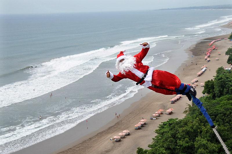 Jeudi 16 décembre, ce père Noël fait un saut à l'élastique au-dessus d'une plage à Kuta, à Bali. 