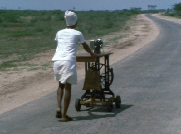 homme poussant une machine a coudre sur une route deserte en Inde homme poussant une machine a coudre sur une route deserte en Inde