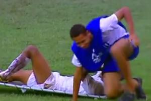 Un brancardiste qui a beaucoup de mal a soulever un joueur blessé Un brancardiste qui a beaucoup de mal a soulever un joueur blessé