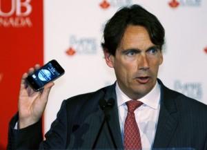 Quebecor CEO Pierre Karl Peladeau holds an Apple iPhone during a speech to business leaders in Toronto Pas d’iPhone dans les émissions à TVA