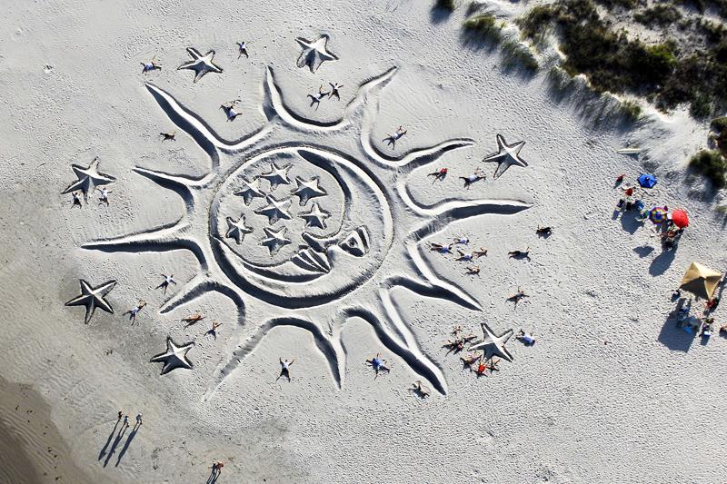 <b></div>DESSIN.<b></b> Des volontaires posent allongés près de l’œuvre de Todd Brittingham intitulée «Le soleil et la lune», à Cap Canaveral, en Floride. L’artiste réalise des «earthwork» depuis plus de 23 ans.