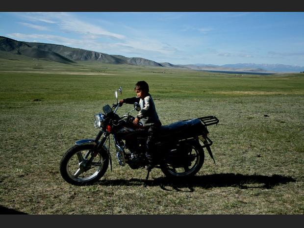 A Tsagaannuur, dans la province de Khövsgöl, la plupart des habitants se déplacent en moto, comme le père de ce jeune garçon (Mongolie). A Tsagaannuur, dans la province de Khövsgöl, la plupart des habitants se déplacent en moto, comme le père de ce jeune garçon (Mongolie).