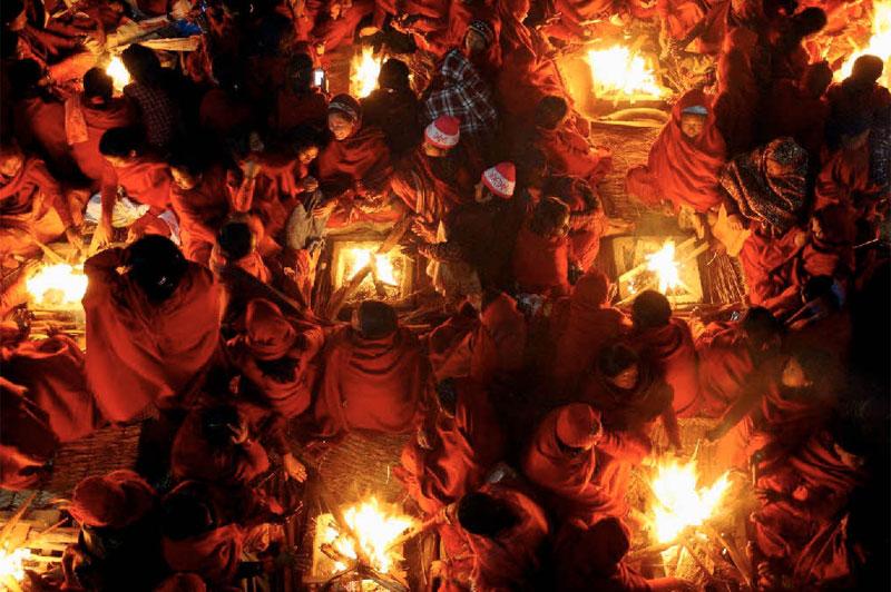 <b></div>Feux sacrés</b>. Ces paysannes népalaises, rassemblées autour de braseros carrés, composent à leur insu une superbe mosaïque de rires et de ferveur. Elles se réchauffent en attendant l’aube du 9 janvier, premier jour du mois sacré de Magh, où les hindouistes népalais (87%de la population) célèbrent aussi la fin du mois de Poush, celui des mauvais présages. Dans quelques heures, ces adoratrices de Vishnou s’immergeront dans la rivière Saali, avant d’entamer tout un mois de réjouissances religieuses. Un bain moins frigorifiant qu’on pourrait le croire ; car le 9 janvier a beau être considéré au Népal comme «le jour le plus froid de l’année», sa température dans la vallée de Katmandou descend rarement en dessous de 15 °C. 