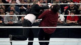Mick Foley est agressé a coup de micro par le GM de Raw John Laurinaitis