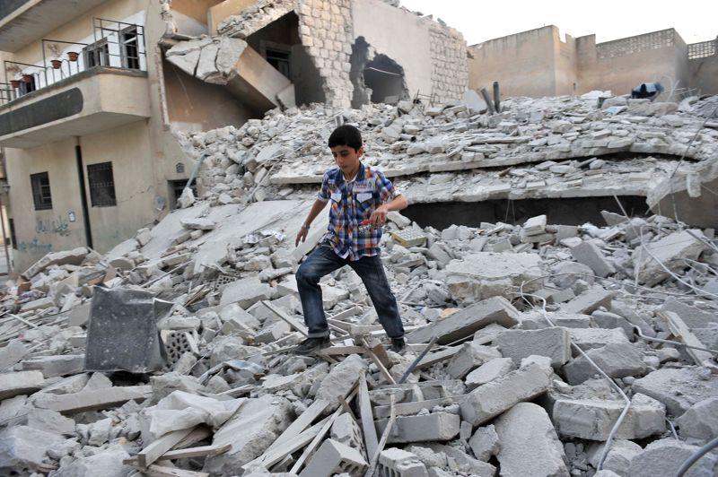 Raid. Ce jeune garçon est un rescapé. Il court sur les décombres des bâtiments détruits suite à un raid aérien contre la ville de Maaret al-Noomane, dans le nord-ouest de la Syrie, ce jeudi. Des chasseurs-bombardiers de l'aviation syrienne, avaient survolé la ville rebelle et sa région pendant toute la matinée, faisant de brefs piqués à basse altitude pour larguer une dizaine de bombes, detruisant totalement ou partiellement deux immeubles et une mosquée où se trouvaient de nombreux civils, femmes et enfants. Au moins 44 personnes ont été tuées et 30 autres sont portées disparues. Maaret al-Noomane est ville stratégique car située sur la route reliant Damas à Alep, et a été prise il y a près de deux semaines par les insurgés.