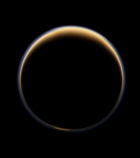 Le côté 'sombre' de Titan auréolé par la lumière du soleil qui forme un anneau coloré autour de la lune (Crédits : NASA/JPL-Caltech/SSI )