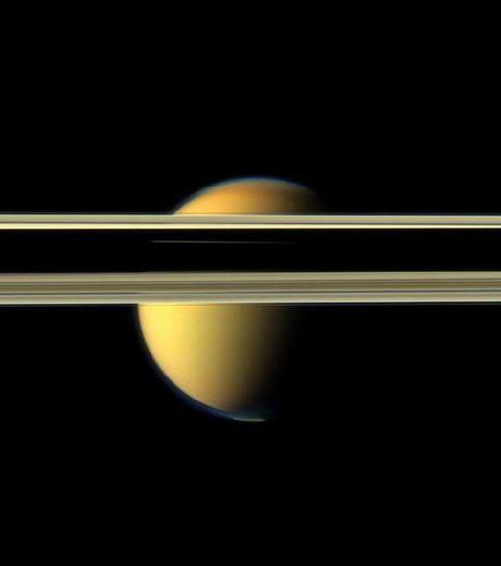 Le visage coloré de Titan obstrué par les obscurs anneaux de la planète Saturne (Crédits : NASA/JPL-Caltech/SSI )