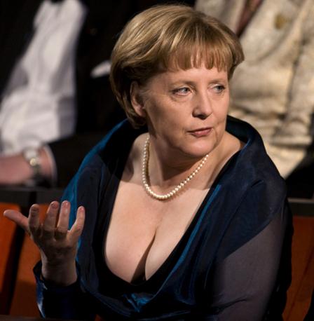 Het decolleté van Merkel is opvallend omdat ze zich tot nu toe hulde in uiterst ingetogen kleding, ook tijdens feestelijke gelegenheden.   (Foto Reuters)