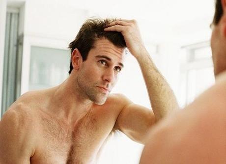 close-up of a man checking his hair in the mirror