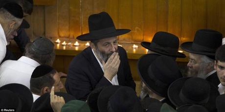 Arye Deri (au centre), chef de file du parti ultra-religieux Shas, regarde près du corps du rabbin Ovadia Yosef