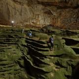 Hang Son Doong explorers navigate an algae-covered cavescape.