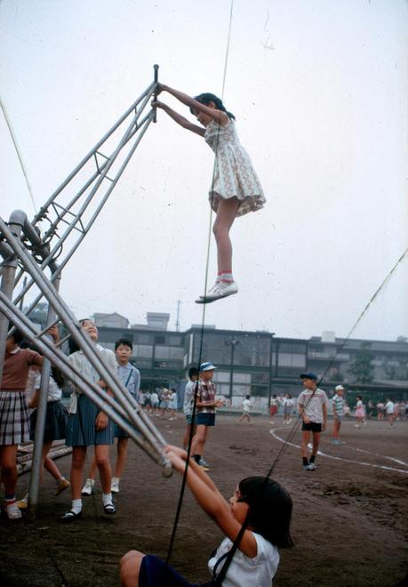 A school girl soars twice her height in a standing version of a seesaw in Tokyo, Japan, November 1964.Photograph by Winfield Parks, National Geographic