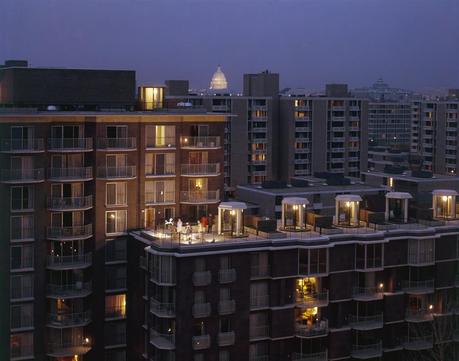 People gather on a roof terrace in the District of Columbia as lights come on in nearby buildings, April 1967.Photograph by Joe Scherschel, National Geographic