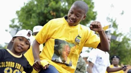 Les gens chantent et dansent pendant la collecte de deuil sur Vilakazi Street à Soweto où l'ancien président sud-africain Nelson Mandela a résidé quand il vivait dans le canton