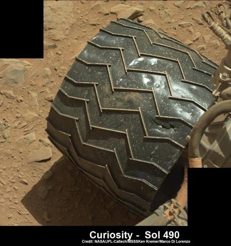 Une des six roues motrices de Curiosity endommagée par les roches pointus qui jonchent le sol - photo prise lors du sol 490 (décembre 2013) 