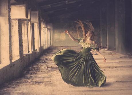 photo de Katerina Plotnikova d'une jeune femme faisant valser sa robe verte dans la poussière  