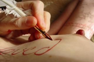 Poitrines et seins: galerie photo ronde et grâcieuse! Une main écrit à la plume sur un sein