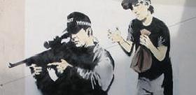 Banksy un tag représentant un enfant faisant peur à un sniper