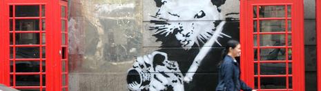 Banksy - un tag représentant un rat muni d'un appareil photo entre deux cabine téléphonique londoniene