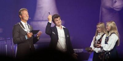 Le champion du monde d'échecs Magnus Carlsen montre le roi noir - Photo © site officiel
