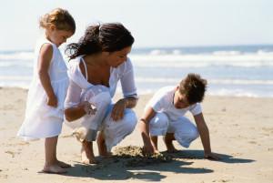 Mother and children searching for shells on the beach