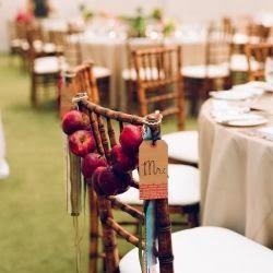 décoration DIY pour mariage d'automne et d'hiver . Chaise en bois et guirlande de pommes rouge , belle décoration de mariage aux couleurs de l'automne