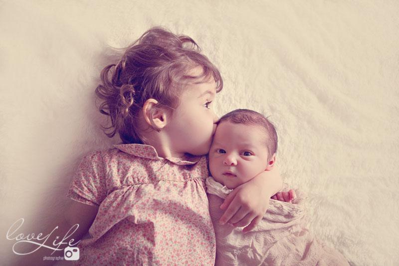 bébé et sa soeur se font un bisou