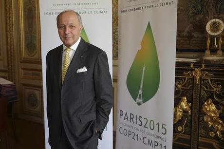 Le ministre des affaires étrangères, Laurent Fabius, vendredi 22 mai, devant l'affiche de la 21e conférence de l'ONU sur le climat, qui se déroulera en décembre à Paris.