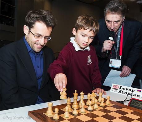 Un jeune joueur d'échecs suggère 1.Cf3 comme premier coup à Levon Aronian, sous le regard de l'organisateur et maître international Malcolm Pein - Photo © Ray Morris-Hill