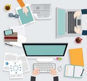 Le journaliste et les réseaux sociaux : visibilité et viralité assurées ! Realistic workplace organization. Top view with textured table, computer, smartphone, graphic tablet, note paper, glasses, newspaper, diary and coffee mug.