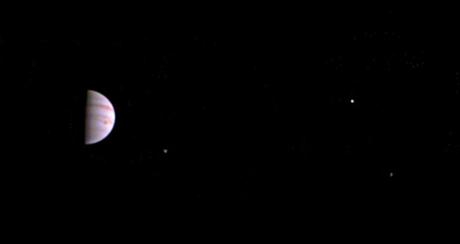 La JunoCam a bien survécu à sa première approche de Jupiter. L’image a été prise 5 jours après son arrivée, le 5 juillet 2016. La Grande tache rouge est bien visible sur le globe de Jupiter et trois de ses quatre satellites galiléens : Io, le plus proche, Ganymède, en bas à droite, et Europe, au-dessus à droite — Crédit : NASA, JPL-Caltech, SwRI, MSSS