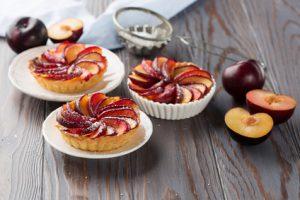 Tartlets with plum on rustic background