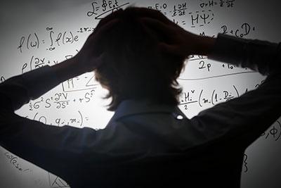 Photograph of a person struggling with equations